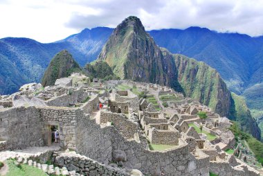Machu Picchu ya da Machu Pikchu Quechua machu yaşlı, yaşlı, pikchu piramidi; dağ ya da geniş tabanlı ve keskin tepelerle biten bir çıkıntı