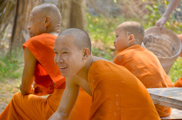 LUANG PRABANG LAOS - MARCH 31: Monks rest after work to resurface the roof and repaint their pagoda on march 30 2013 in Luang Prabang Laos Buddhism is the faith of 96% of the Lao population. 