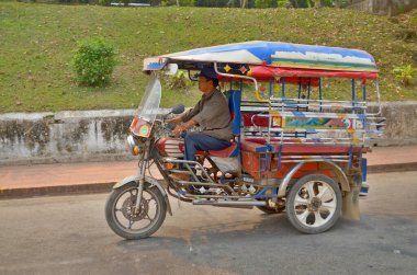 VİANE LAOS - 3 Nisan 2013 'te Vientiane Laos' ta sokakta Tuk Tuk. Otomobil çekçekçekleri (Tuk Tuk) dünyanın birçok ülkesinde toplu taşımacılık için yaygın bir araçtır..