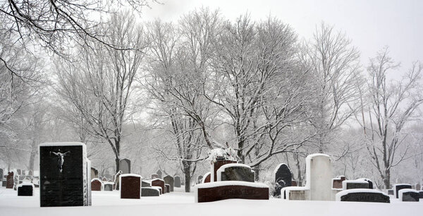 MONTREAL CANADA - 02 15 2017: During snow storm the Notre Dame Des Neiges church cemetery is a Catholic cemetery open to other faiths.