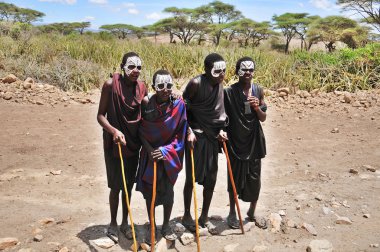 SERENGETİ, TANZANIA - 20 Ekim 2011: Tanımlanamayan Genç Masai erkekleri (Moran) 20 Ekim 2011 'de sünnet olduktan sonra birkaç ay boyunca siyah ve işaret takarlar..