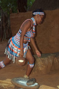 Kimliği belirsiz genç bir kadın geleneksel Zulu giysileri giyiyor, 27 Kasım 2010 'da Shakaland Zulu Kültür Köyü, KwaZulu-Natal, Güney Afrika' da buğdaylı yerel bira yaptı.