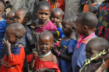 AMBOSELI, KENYA - 13 Ekim 2011 'de Kenya, Amboseli' de inek gübresiyle yapılan evde yaşayan, Masai kabilesinden kimliği belirsiz Afrikalı çocuklar.