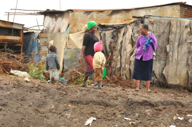 Nairobi gecekondu mahallesinde 13 Ekim 2011 'de Nairobi, Kenya' da kimliği belirsiz insanlar çamurda yürüyor. Kibera, Nairobi 'nin en büyük gecekondu mahallesi ve Afrika' nın en büyük ikinci kenar mahallesidir.