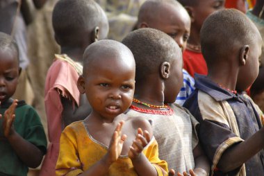 AMBOSELI, KENYA - 13 Ekim 2011 'de Kenya, Masai Mara' da inek gübresi ile evde yaşayan kimliği belirsiz Afrikalı çocuklar.