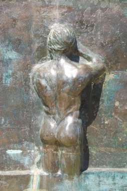 Güneş ışığında insanın sırtında bronz bir anıt