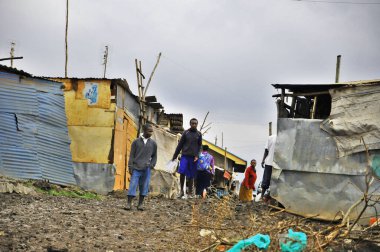 Nairobi gecekondu mahallesinde 13 Ekim 2011 'de Nairobi, Kenya' da kimliği belirsiz insanlar çamurda yürüyor. Kibera, Nairobi 'nin en büyük gecekondu mahallesi ve Afrika' nın en büyük ikinci kenar mahallesidir.