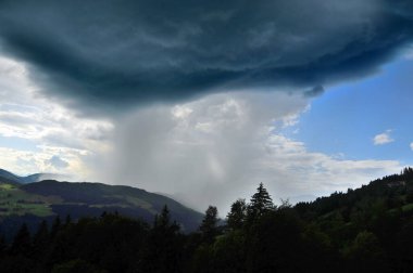 Bulutlu bir günde Alpler 'de dağ kepçesi