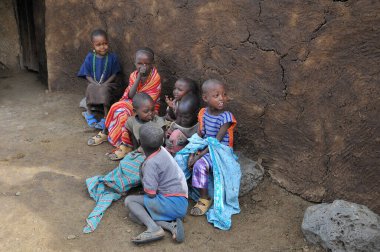 AMBOSELI, KENYA - 13 Ekim 2011 'de Kenya, Amboseli' de inek gübresiyle yapılan evde yaşayan, Masai kabilesinden kimliği belirsiz Afrikalı çocuklar.