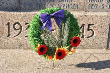 Güzel dekoratif çelenk ve savaş anıtının yanında çiçekler.