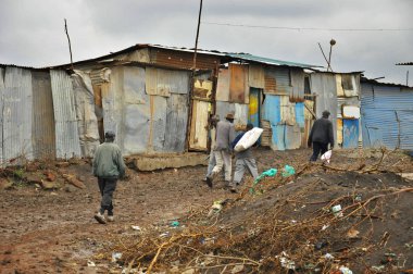 Nairobi gecekondu mahallesinde 13 Ekim 2011 'de Nairobi, Kenya' da kimliği belirsiz insanlar çamurda yürüyor. Kibera, Nairobi 'nin en büyük gecekondu mahallesi ve Afrika' nın en büyük ikinci kenar mahallesidir.