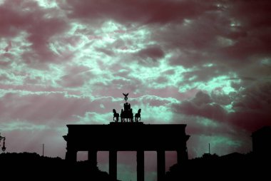 The Brandenburg Gate, neoclassical monument in Berlin, neon clouds  clipart