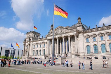Alman bayrağı Alman parlamento binası önünde dalgalanmakta, Berlin, Almanya 'daki Reichstag.