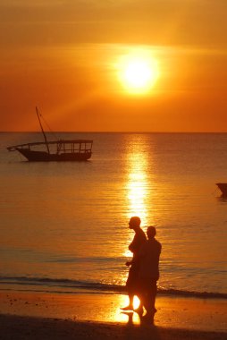 Denizdeki uzun bir günün ardından gün batımında Dhow Boat balıkçıları. Tanzanya 'nın Zanzibar Adası' ndaki Nungwi köyünde çekildi.