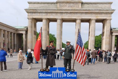 BERLIN, GERMANY - MAY 19: Unidentified young men dress as Russian and American soldiers stand in front the check point Charlie remembering the cold war on May 19, 2010 in Berlin Germany clipart