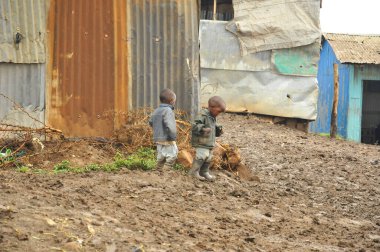 Nairobi gecekondu mahallesinde 13 Ekim 2011 'de Nairobi, Kenya' da kimliği belirsiz insanlar çamurda yürüyor. Kibera, Nairobi 'nin en büyük gecekondu mahallesi ve Afrika' nın en büyük ikinci kenar mahallesidir.