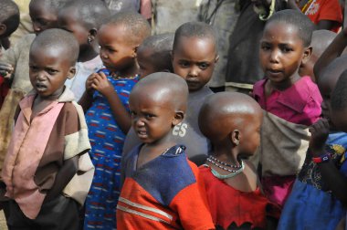 AMBOSELI, KENYA - 13 Ekim 2011 'de Kenya, Amboseli' de inek gübresiyle yapılan evde yaşayan, Masai kabilesinden kimliği belirsiz Afrikalı çocuklar.