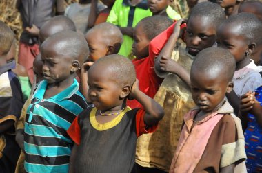 AMBOSELI, KENYA - 13 Ekim 2011 'de Kenya, Masai Mara' da inek gübresi ile evde yaşayan kimliği belirsiz Afrikalı çocuklar.