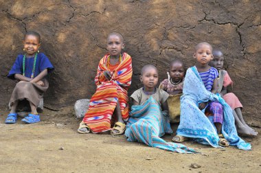 AMBOSELI, KENYA - 13 Ekim 2011 'de Kenya, Masai Mara' da inek gübresi ile evde yaşayan kimliği belirsiz Afrikalı çocuklar.