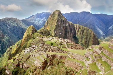 Machu Picchu ya da Machu Pikchu Quechua machu yaşlı, yaşlı, pikchu piramidi; dağ ya da geniş tabanlı ve keskin tepelerle biten bir çıkıntı