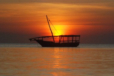 Gün batımında balıkçı teknesi, Nungwi Köyü, Zanzibar Adası, Tanzanya Nungwi 'de çekildi. Nungwi geleneksel olarak Zanzibar 'ın dhow-building endüstrisinin merkezidir.. 