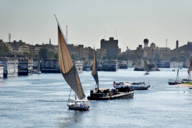 ASWAN EGYPT - 125 08: Felucca, Aswan, Mısır yakınlarındaki Nil nehri üzerinde yelken açıyor. Bugün görülen dostlar MÖ 3350 yılında icat edildi.