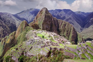 Machu Picchu ya da Machu Pikchu Quechua machu yaşlı, yaşlı, pikchu piramidi; dağ ya da geniş tabanlı ve keskin tepelerle biten bir çıkıntı