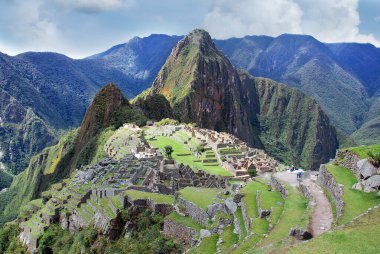 Machu Picchu ya da Machu Pikchu Quechua machu yaşlı, yaşlı, pikchu piramidi; dağ ya da geniş tabanlı ve keskin tepelerle biten bir çıkıntı