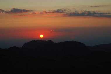 Ürdün 'deki Wadi Rum vadisinde, dağların tepesinde çölde gün batımı