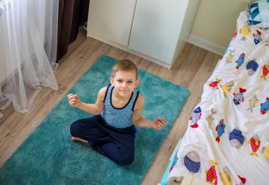 Çocuk odasında antrenman yapıyor. Sağlıklı yaşam tarzı kavramı. Evde spor haberleri. Kişisel izolasyon.