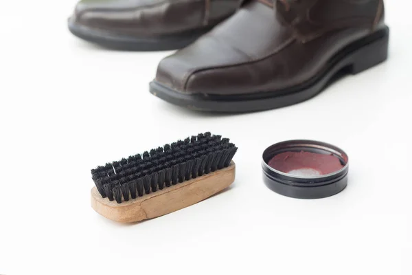 Темно-коричневая обувь с лаком для обуви и щеткой — стоковое фото