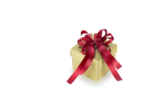 Caixa de presente de ouro com fita vermelha — Fotografia de Stock