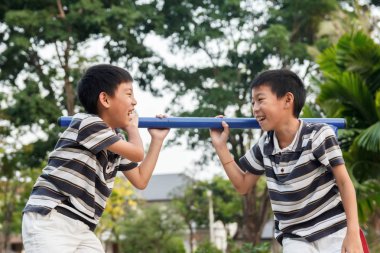 İkiz kardeşi oynayan ve gülüyor.