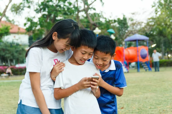 Schwester und Zwillingsbruder nutzen Smartphone. lizenzfreie Stockbilder