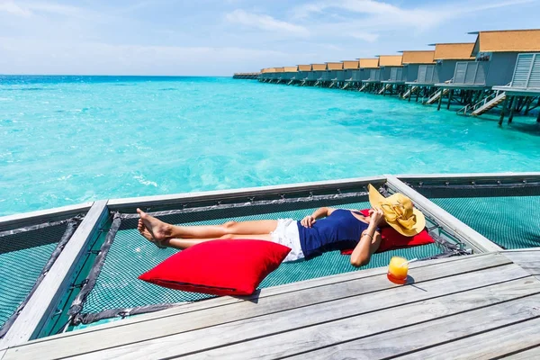 Mujer dormir en la red sobre el mar . — Foto de Stock