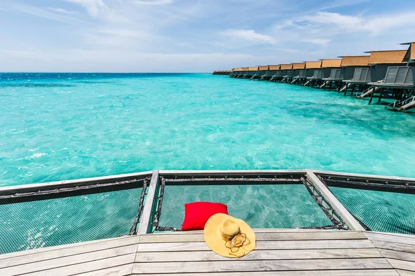 Sombrero y almohada en la red sobre el mar . — Foto de Stock