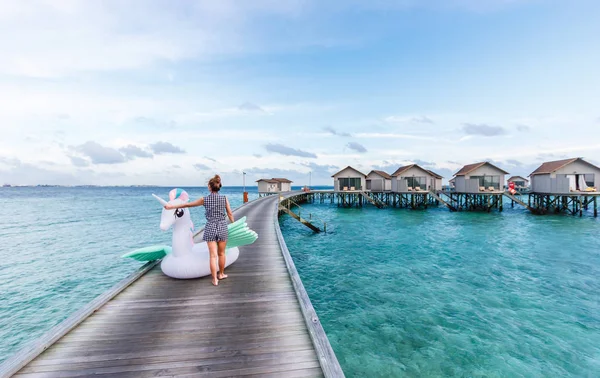 Mujer asiática sosteniendo pegaso piscina flotar en Maldivas . — Foto de Stock
