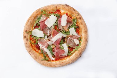 Jamonlu geleneksel pizza ve beyaz arka planda otlar.