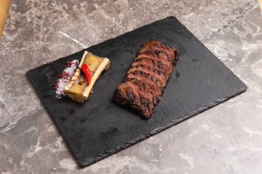 Biftek ve kemik taş bir levhada