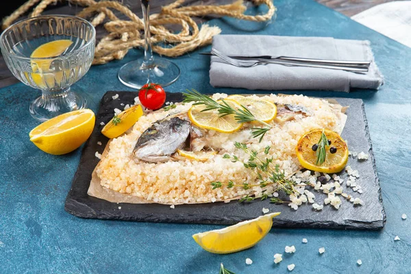 Mavi arka planda tuzla pişirilmiş Dorado balığı.