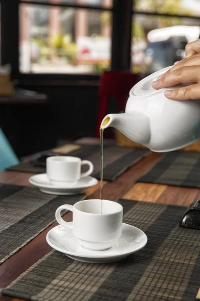 Tee Aus Einer Teekanne Eine Tasse Auf Einem Holztisch Gießen — Stockfoto