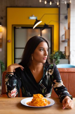 Bir kafede genç bir kız makarna yiyor. seçici odak