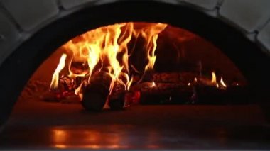 Yanan bir odun sobasında ateş yanıyor. Pizza fırını