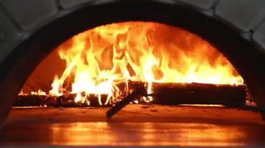 Yanan bir odun sobasında ateş yanıyor. Pizza fırını