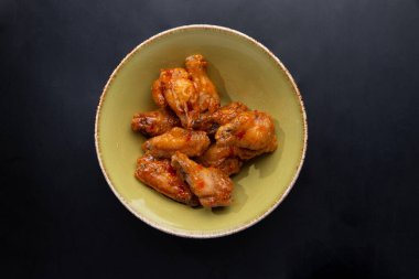 Koyu arkaplanda kızarmış tavuk bacağı.