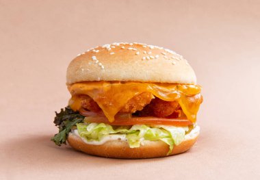 Kahverengi arka planda tavuklu klasik hamburger. yakın plan