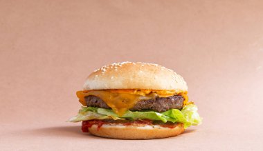 Kahverengi arka planda peynirli klasik burger. yakın plan