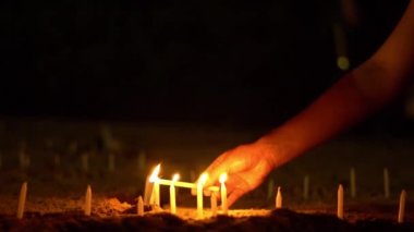 Dini tören, rüzgarlı kuma Asya mum. İnsanlar mum ışığı. Ağır çekim