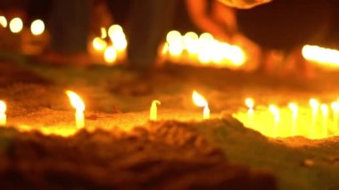 Dini tören, rüzgarlı kuma Asya mum. İnsanlar mum ışığı. Ağır çekim