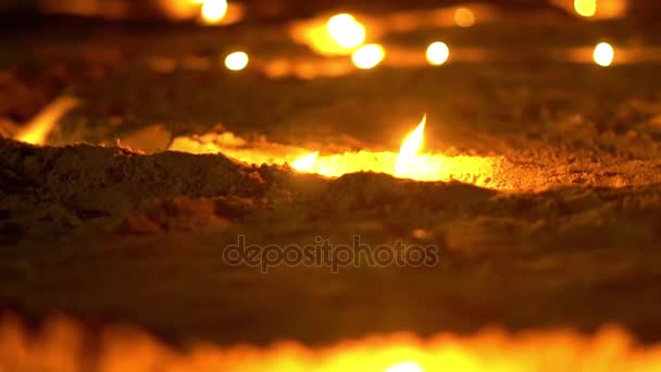 Азиатские свечи в песке на религиозной церемонии, ветрено. Слайд. Медленное движение — стоковое видео